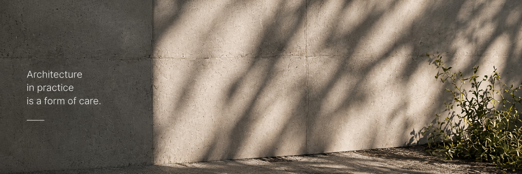 Sunlight and tree shadows on a stone wall. Architecture in practice is a form of care.